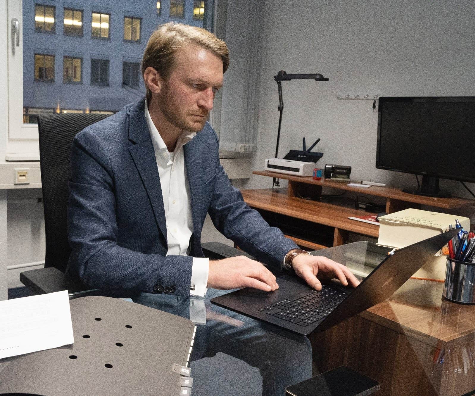 Anwalt Steininger am Schreibtisch mit Laptop